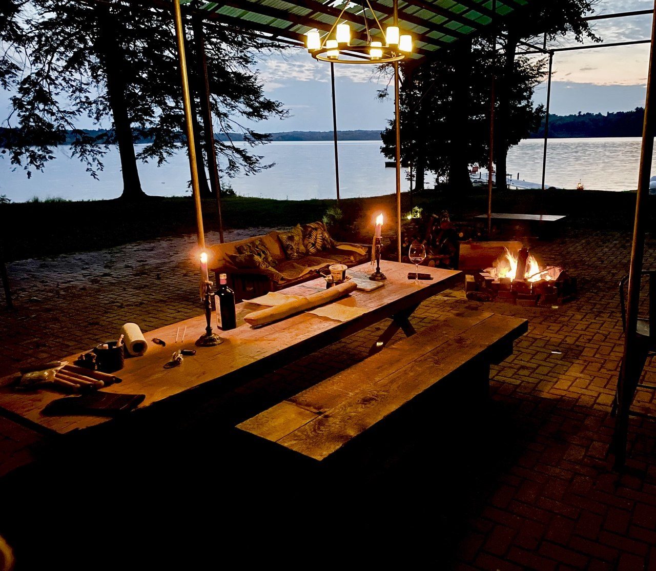 The pavilion with a long table and fire at dusk